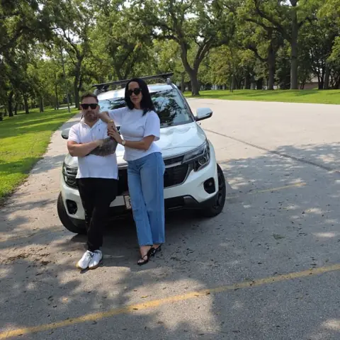 Agustín and Claudia of Wolf Premier Drive with one of their cars in Omaha
